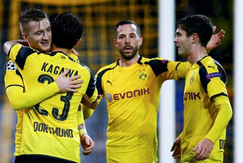Gelandang Borussia Dortmund Marco Reus berpelukan dengan Shinji Kagawa setelah mencetak gol ke gawang Legia Warsawa.