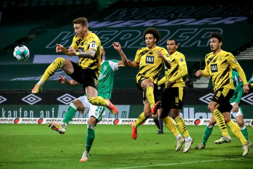 Gelandang Borussia Dortmund Marco Reus (kiri) beraksi saat menghadapi Werder Bremen di Bundesliga, Rabu (16/12) dini hari WIB.  