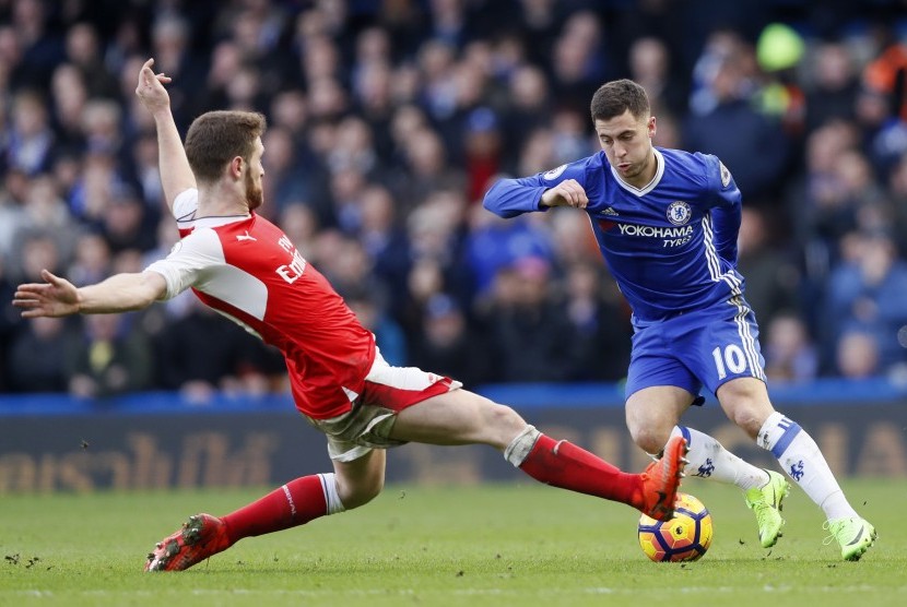 Gelandang Chelsea, Eden Hazard (kanan) mencoba melewati adangan bek Arsenal, Skordan Mustafi pada laga Liga Primer di Stamford Bridge, Sabtu (4/2). Hazard mencetak satu gol pada laga ini.