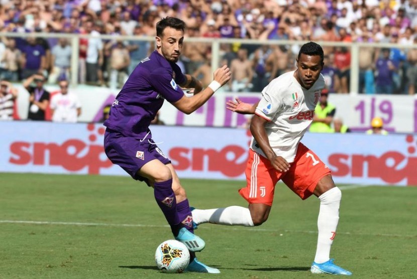 Gelandang Fiorentina Gaetano Castrovilli (kiri) berduel dengan winger Juventus Alex Sandro dalam pertandingan di Stadion Artemio Franchi, Florence, Italia, Sabtu (14/9).