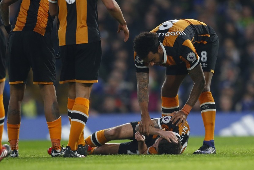 Gelandang Hull City, Ryan Mason tergeletak sambil memegangi kepalanya setelah berbenturan dengan bek Chelsea, Gary Cahill pada laga Liga Primer di Stamford Bridge, Senin (23/1) dini hari WIB. Mason mengalami cedera serius.