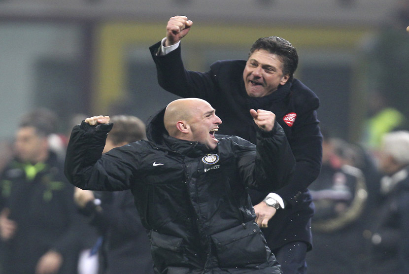 Gelandang Inter Milan asal Argentina Esteban Cambiasso (bawah) dan pelatih Inter Milan Walter Mazzarri merayakan kemenangan usai mengalahkan AC Milan pada pertandingan Serie A di stadion San Siro, Milan, Ahad (22/12).   (AP/Antonio Calanni)