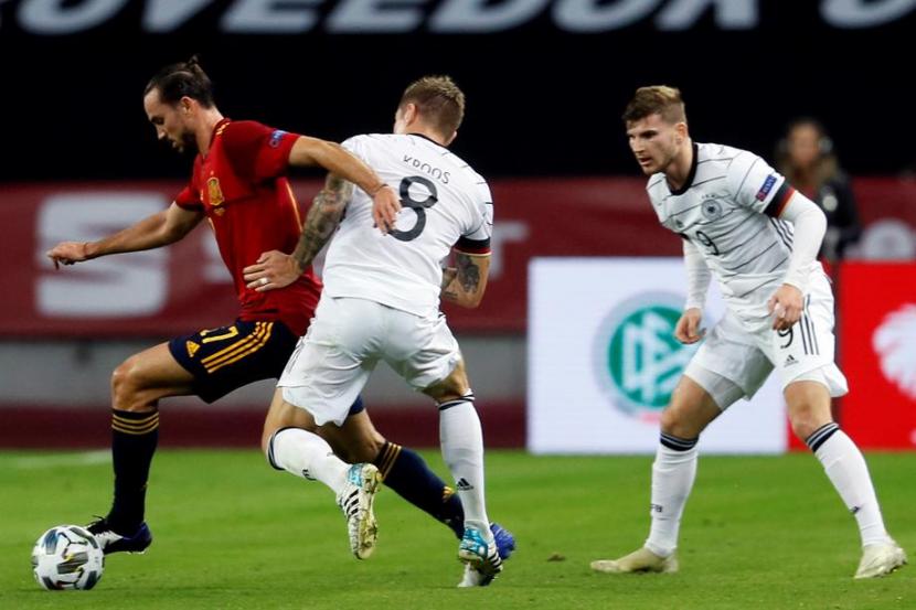 Gelandang Jerman Toni Kroos (tengah) saat berusaha merebut bola dari kaki pemain Spanyol Fabian Ruiz.