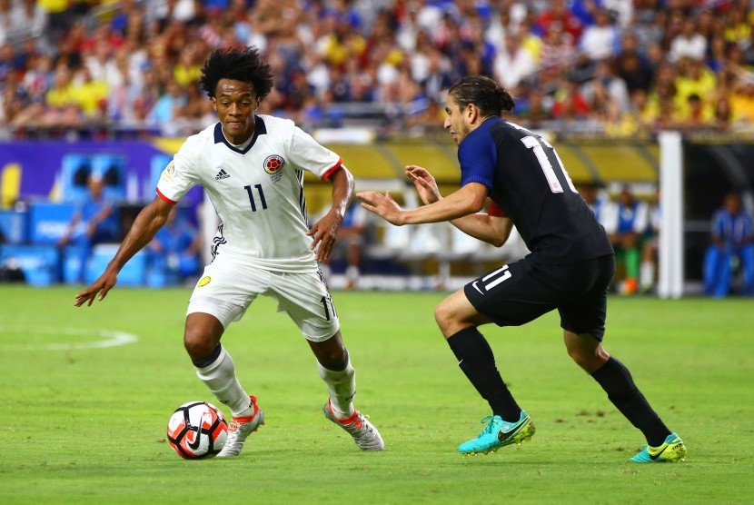 Gelandang Kolombia Juan Cuadrado (kiri) sedang mengontrol bola untuk melewati pemain Amerika Serikat Alejandro Bedoya pada saat kedua tim bertemu untuk memerebutkan tempat ketiga Copa America di University of Phoenix Stadium