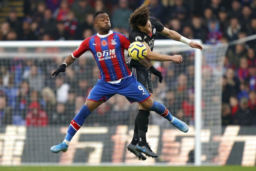 Bek Leicester City Caglar Soyuncu (kanan) berebut bola dengan pemain Crystal Palace Jordan Ayew di Selhurst Park, London, Ahad (3/11). 