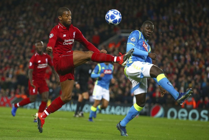 Gelandang Liverpool Georginio Wijnaldum dibayangi bek Napoli Kalidou Koulibaly (kanan) pada laga Grup C Liga Champions antara Liverpool melawan Napoli  di stadion Anfield, Liverpool, (12/12) dini hari.