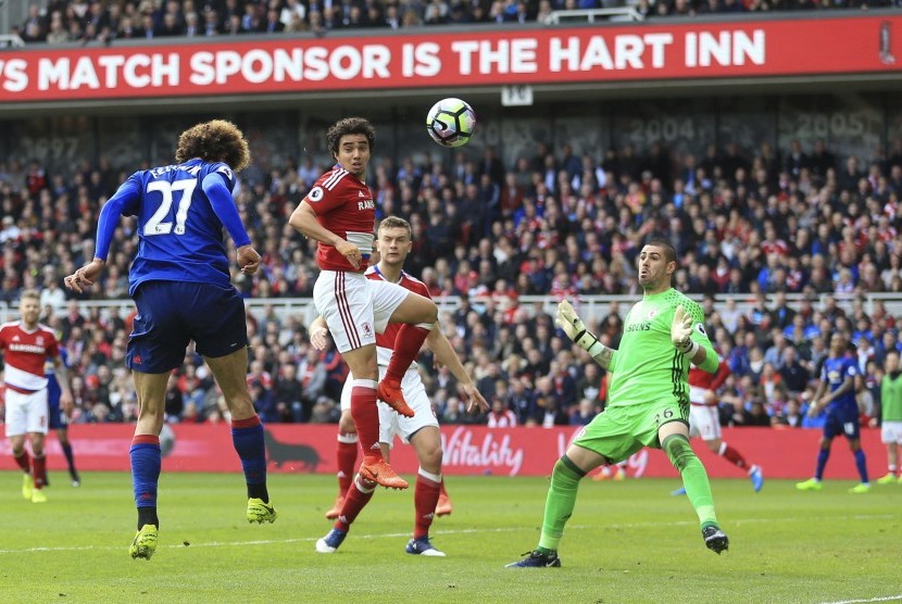 Gelandang Manchester United, Marouane Fellaini (kiri) menanduk bola masuk ke gawang Middlesbrough pada laga Liga Primer Inggris, di stadion Riverside, Ahad (19/3). United unggul 1-0 pada babak pertama.