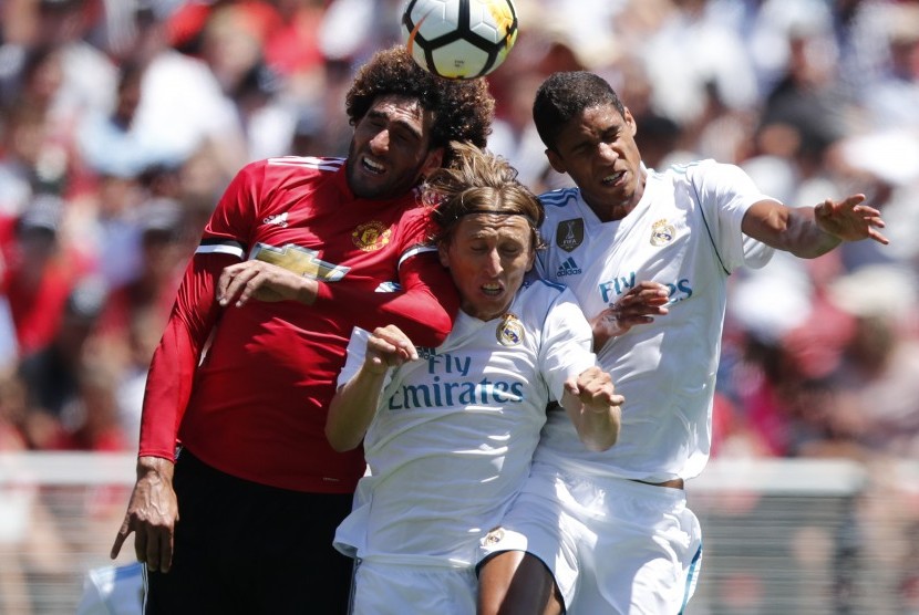 Gelandang Manchester United, Marroune Fellaini (kiri) berebut bola dengan dua pemain Real Madrid, Luka Modric (tengah) dan Raphael Varane pada laga Piala Champions Internasional di Stadion Levi's, Kalifornia, Amerika Serika, Senin (24/7). MU menang lewat adu penalti.