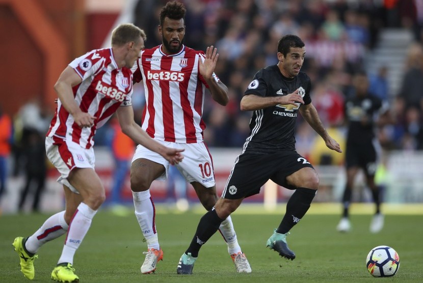 Gelandang Manchester United (MU), Henrikh Mikhtaryan (kanan) menggiring bola dalam penjagaan dua pemain Stoke City pada laga Liga Primer Inggris di Stadium Bet365, Ahad (10/9) dini hari WIB. Laga berakhir imbang 1-1 pada babak pertama.