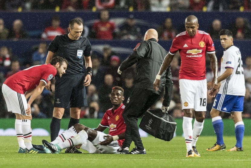 Gelandang Manchester United (MU), Paul Pogba terduduk karena cedera pada laga Liga Champions lawan FC Basel di Old Trafford pekan lalu. Pogba diperkirakan akan cedera panjang.