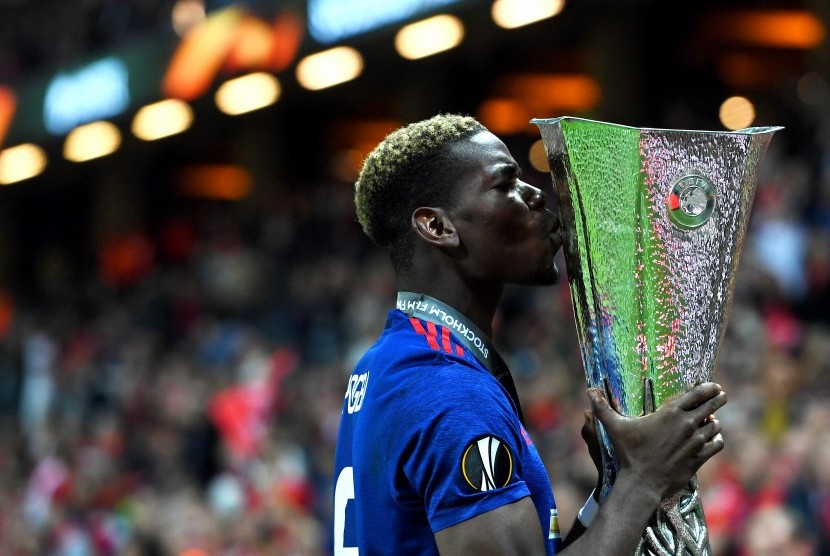 Gelandang Manchester United, Paul Pogba mencium trofi Liga Europa setelah timnya menang pada laga final atas Ajax Amsterdam di Friends Arena, Kamis (25/5) dini hari WIB. United menang 2-0.