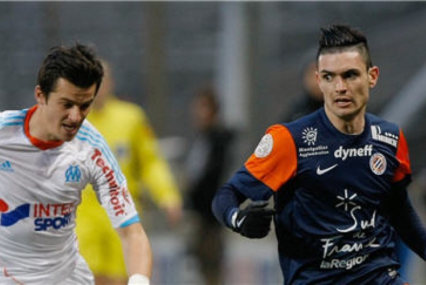 Gelandang Marseille, Joey Barton (kiri), berebut bola dengan gelandang Montpellier, Remy Cabella, dalam laga Ligue 1 Prancis di Marseille. 