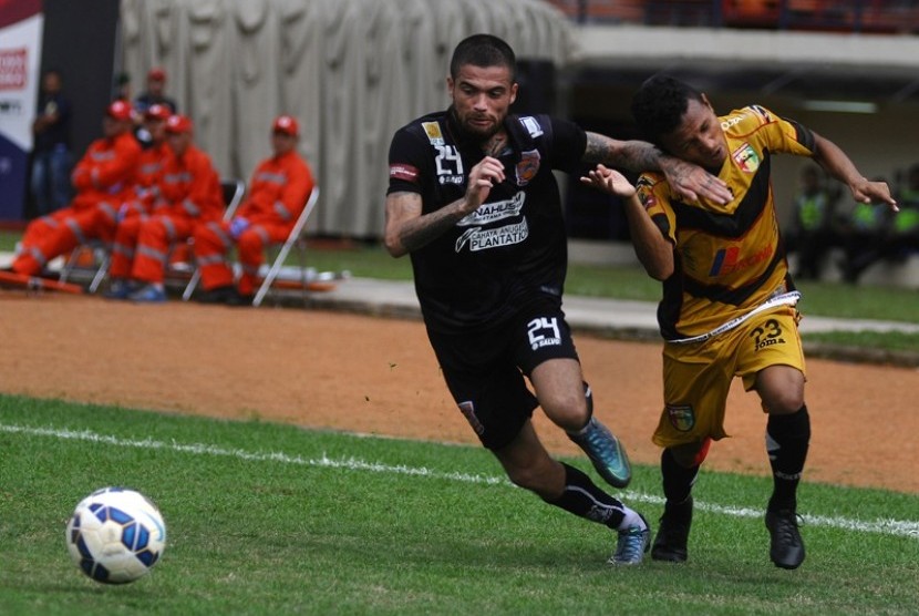 Gelandang Mitra Kukar Hendra Adi Bayauw (kanan) berduel dengan bek Pusamania Borneo FC Diego Michiels.