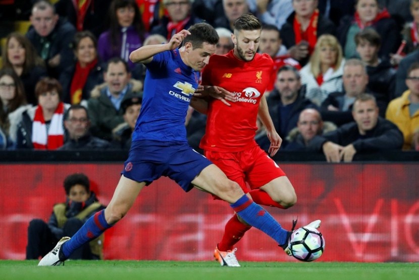 Gelandang MU Ander Herrera (kiri) berusaha menguasai bola meski ditempel ketat pemain Liverpool Adam Lallana.