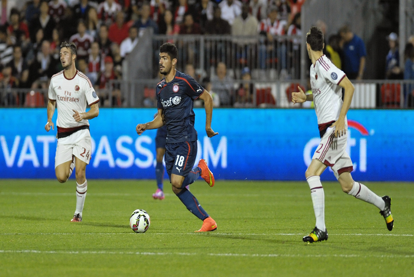 Gelandang Olympiacos Piraeus, Andreas Bouchalakis (tengah), membawa bola di tengah kepungan pemain AC Milan, Bryan Cristante (kiri) dan Andrej Modic, dalam laga International Champions Cup di Toronto, Canada, Kamis (24/7). 