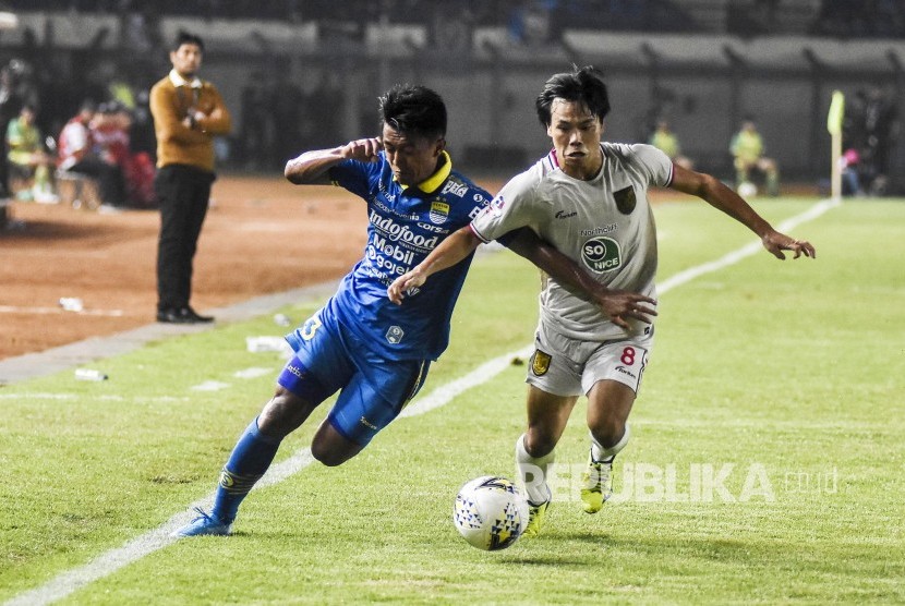 Gelandang Persib Bandung Febri Hariyadi (kiri) berebut bola dengan gelandang Persela Lamongan Kei Hirose (kanan) dalam laga lanjutan Liga 1 2019 di Stadion Si Jalak Harupat, Kabupaten Bandung, Selasa (3/12). 