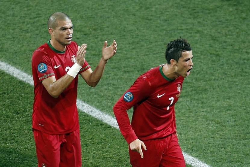  Gelandang Portugal Cristiano Ronaldo diberi aplaus oleh rekannya Pepe (kiri), setelah tampil gemilang dalam pertandingan melawan Belanda di Grup B di Stadion Metalist,Senin (18/6) dini hari WIB.  (Vadim Ghirda/AP)