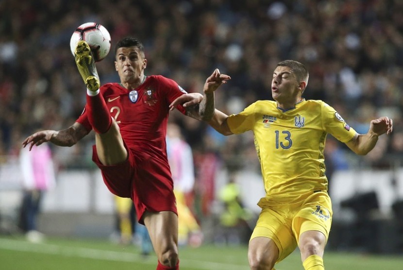 Gelandang Portugal Joao Cancelo (kiri) berebut bola dengan pemain Ukraina Vitaliy Mykolenko dalam laga kualifikasi Piala Eropa 2020. 