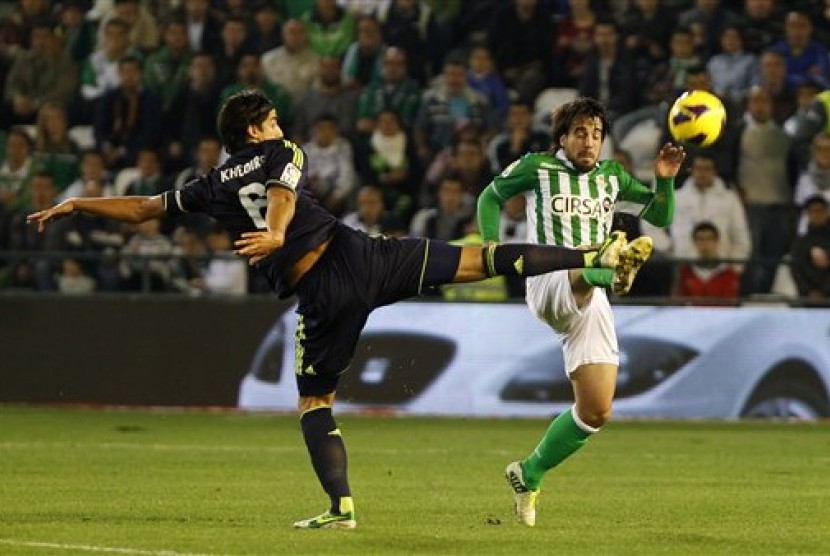 Gelandang Real Betis, Benat Extebarria (kanan) terlihat berebut bola dengan gelandang Real Madrid, Sami Khedira (kiri), pada partai La Liga yang berlangsung di Benito Villamarin Stadium, Ahad (25/11) dini hari. 