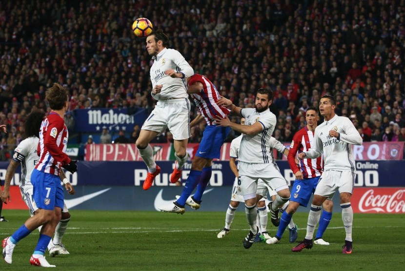Gelandang Real Madrid, Gareth Bale menyundul bola pada laga La Liga lawan Atletico di Vicente Calderon, Ahad (20/11) dini hari WIB. Laga bertajuk Derby Madrileon.