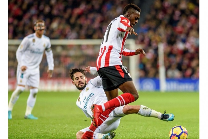 Gelandang Real Madrid, Isco (tengah) berusaha merebut bola dari kaki pemain Athletic Bilbao, Inaki Williams, dalam pertandingan La Liga di Estadio San Mames, Bilbao, Ahad (3/12) dini hari WIB. Laga berakhir imbang tanpa gol 0-0.