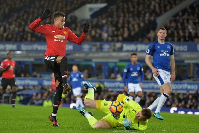 Gelandang serang Manchester United Jesse Lingard (kiri) berduel melawan kiper Everton Jordan Pickford (kanan) pada lanjutan Liga Primer di Goodison Park, Liverpool, Inggris, Selasa (2/1) dini hari WIB. 