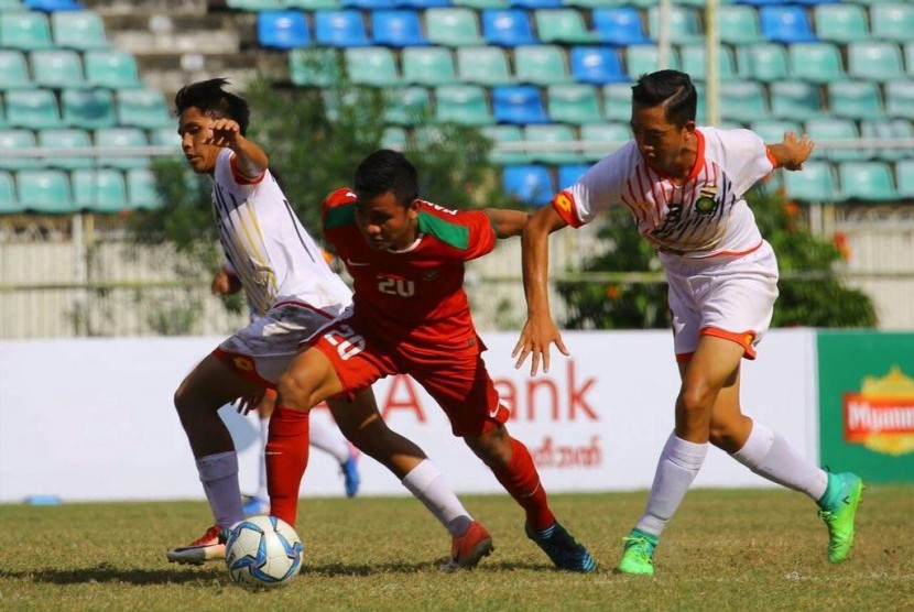 Gelandang timnas Indonesia U-19, Asnawi Mangkualam Bahar (tengah) di antara dua pemain Brunei Darussalam pada laga Piala AFF U-18 di Yangon, Myanmar, Rabu (13/9). Indonesia menang 8-0 pada laga ini.