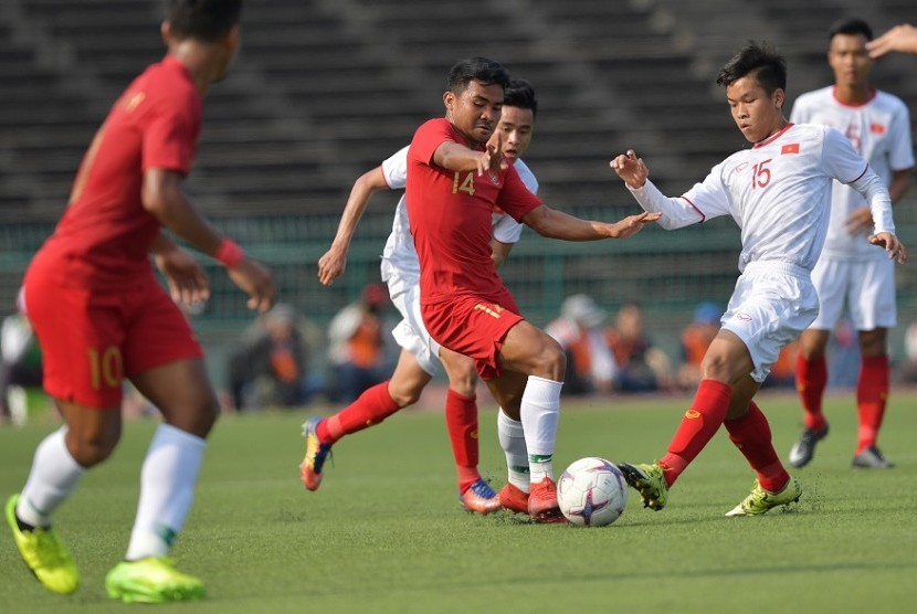 Gelandang timnas Indonesia U-22 Asnawi Mangkualam (tengah) berebut bola dengan pemain Vietnam U-22 pada semifinal Piala AFF U-22, Ahad (24/2).