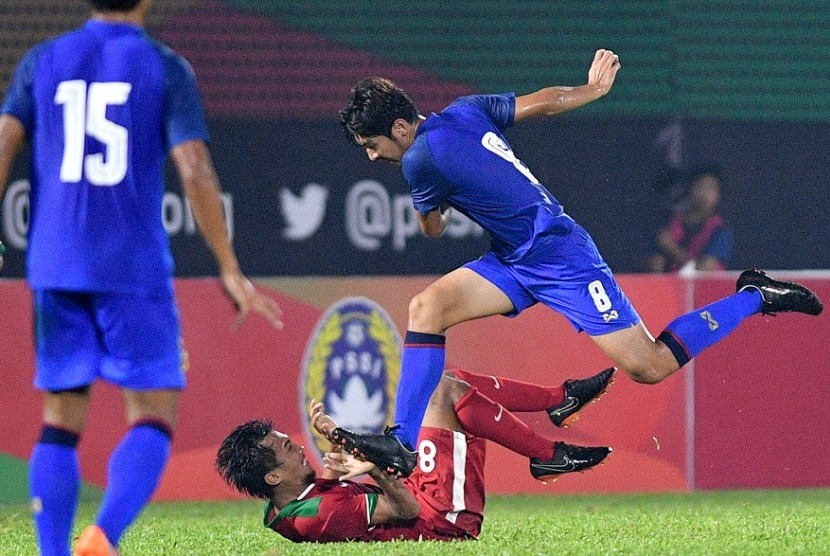Gelandang timnas Indonesia U-23 Muhammad Hargianto (bawah) terjatuh saat berebut bola dengan pemain Thailand U-23 Ratchanat Arunyapairot (kanan) dalam pertandingan persahabatan di Stadion PTIK, Jakarta, Kamis (31/5) malam. Indonesia kalah 1-2 dari Thailand. 