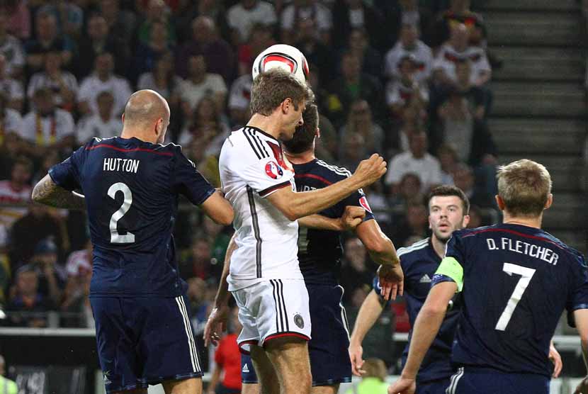 Gelandang Timnas Jerman, Thomas Mueller (dua kiri), melepaskan sundulan menjebol gawang Skotlandia dalam laga pembuka grup Piala Eropa 2016 di Dortmund, Jerman, Ahad (7/9). 