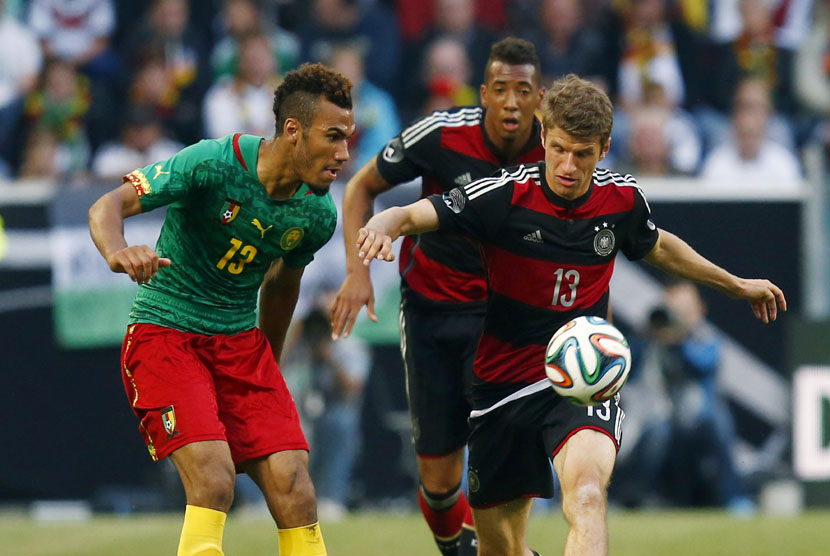 Gelandang timnas Jerman, Thomas Mueller (kanan), berebut bola dengan pemain Kamerun, Eric Choupo-Moting (kiri), dalam laga internasional di Moenchengladbach pada Ahad (1/6). 