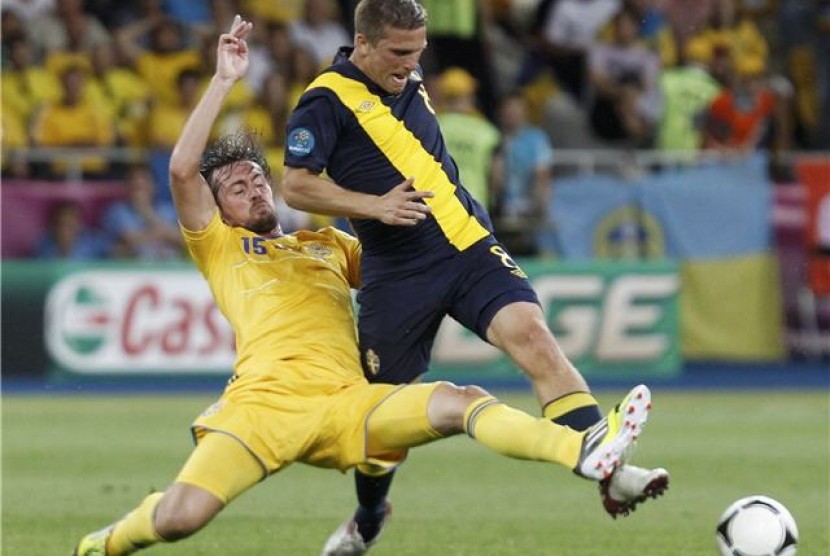 Gelandang timnas Swedia, Anders Svensson (kanan), bertarung dengan pemain Ukraina, Artem Milevskiy, di laga perdana Grup D Piala Eropa 2012 di Kiev, Ukraina, pada Senin (11/6). 