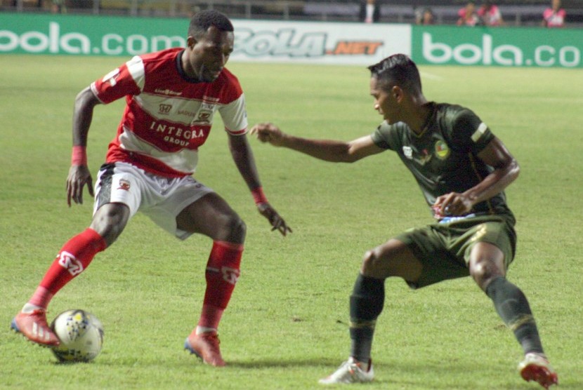 Gelandang Tira Persikabo Abduh Lestaluhu (kanan) berusaha merebut bola dari gelandang Madura United Engelberd Sani (kiri) pada laga Liga 1 2019 di Stadion Pakansari, Bogor, Jawa Barat, Jumat (12/7).