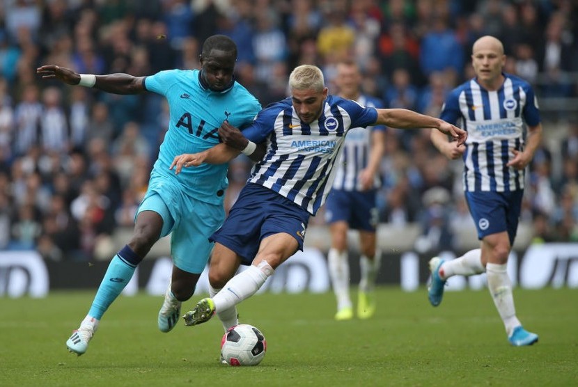 Gelandang Tottenham Hotspur Moussa Sissoko (kiri) berebut bola dengan penyerang Brighton Neal Maupay.