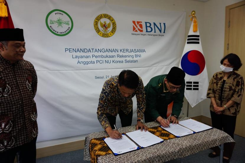 General Manager BNI Cabang Seoul Anisfu (kedua kiri) dan Ketua Tanfidziyah PCI NU Korea Selatan K Ali Nurahim (kedua kanan) menandatangani Perjanjian Kerja Sama Layanan Pembukaan Rekening BNI untuk Pekerja Migran Indonesia di Korea Selatan di Kantor Cabang Luar Negeri BNI Seoul, Korea Selatan pada Ahad  (21/6).