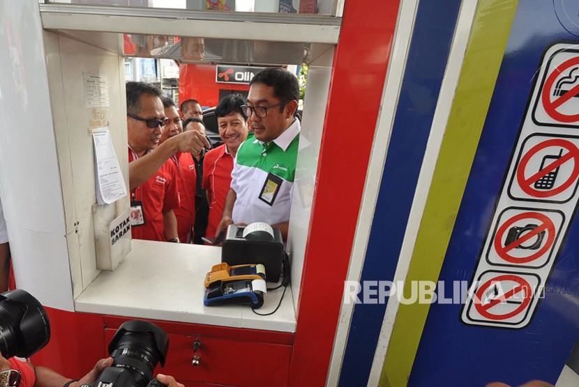General Manager Pertamina MOR IV, Yanuar Budi Hartanto mencoba keandalan proses transaksi non tunai di SPBU dengan T-cash, di SPBU 44.501.40 Jalan Jendral Sudirman Semarang, Rabu (13/12). 