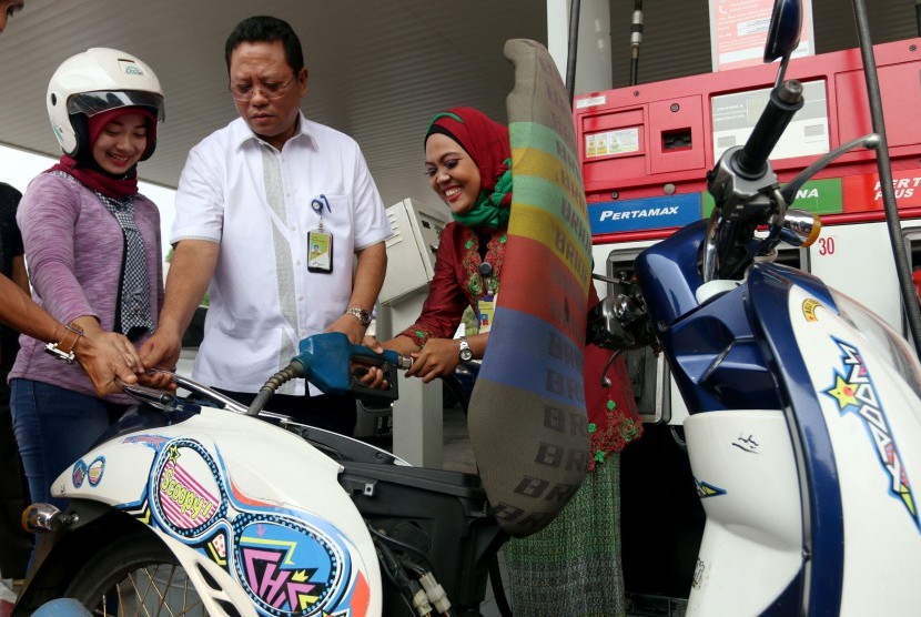 General Manager PT Pertamina MOR I, Romulo Hutapea (tengah) melihat proses pengisian bahan bakar minyak yang dilakukan petugas SPBU yang mengenakan kebaya, di Medan, Sumatera Utara, Kamis (21/4). 