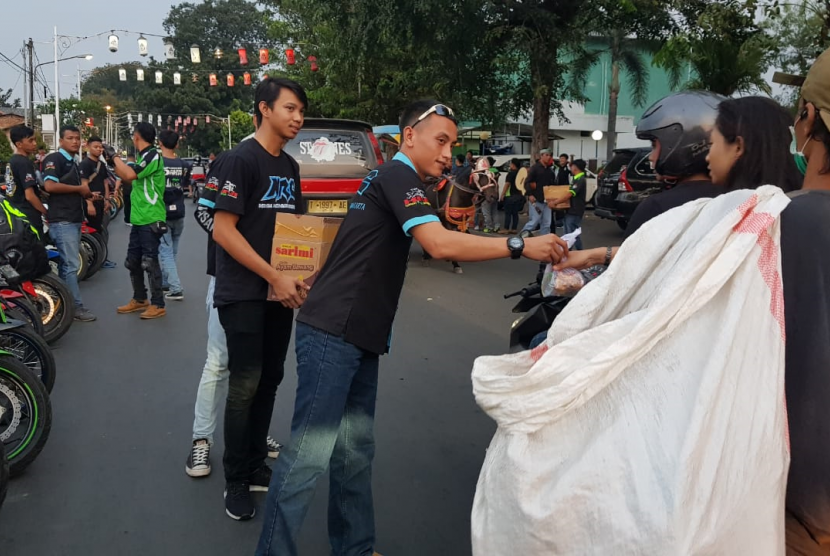 Klub penggemar motor yang tergabung dalam komunitas Kawasaki Ninja Indonesia (KNI) chapter Purwakarta, membagikan takjil gratis bagi pengendara yang melintasi Lapang Sahate, Jl KK Singawinata, Purwakarta, Kamis (30/5). 