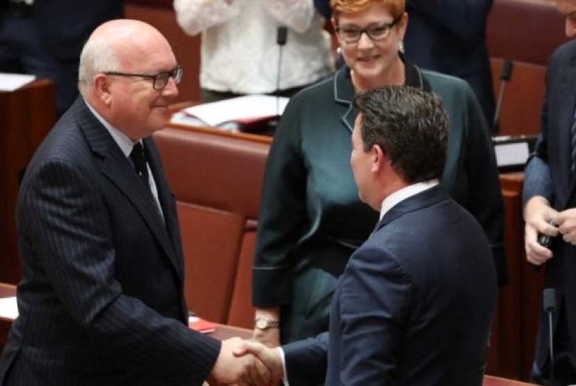 George Brandis dan Dean Smith berjabat tangan setelah RUU Pernikahan Sesama Jenis lolos di Senat.