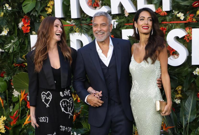George Clooney (tengah) beradu akting dengan Julia Robert (kiri) dalam film baru Ticket to Paradise. 