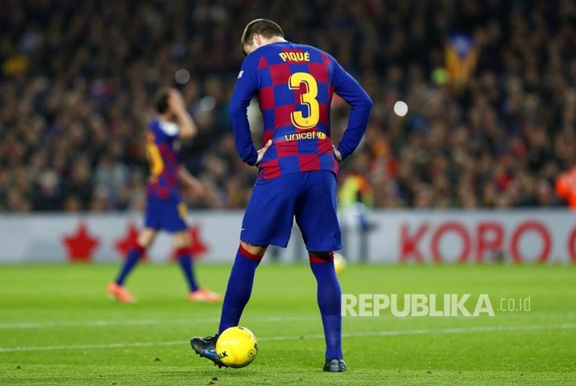 Bek Barcelona Gerard Pique memainkan bola.