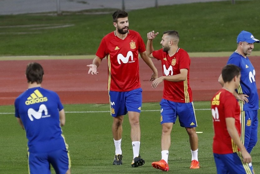 Gerard Pique (kedua kiri) bercengkrama dengan Jordi Alba dalam latihan timnas Spanyol di Las Rozas, Madrid, Senin (2/10).