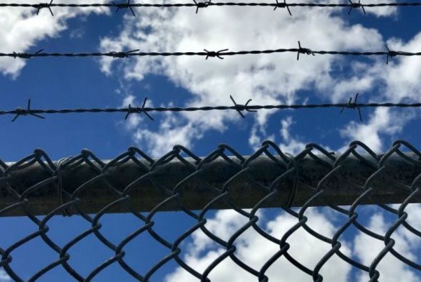 Gerbang pagar yang tinggi dengan kawat berduri di puncaknya mengelilingi kompleks kebun ganja obat berlisensi Medifarm di wilayah Sunshine Coast, Australia.