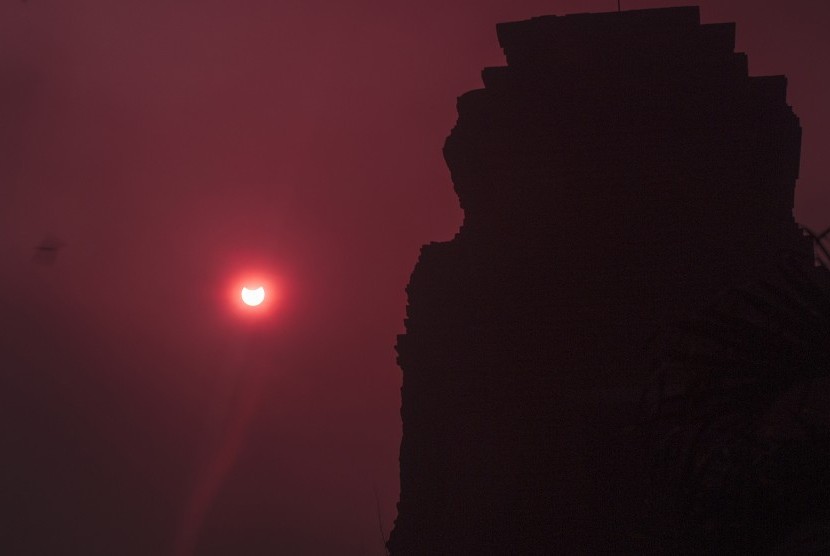 Gerhana Matahari Sebagian (GMS) terlihat dari kawasan Candi Brahu, Trowulan, Mojokerto, Jawa Timur, Rabu (9/3).