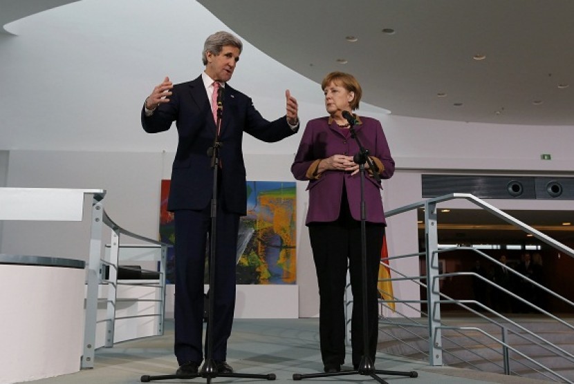 German Chancellor Angela Merkel and US Secretary of State John Kerry speak to media at the Chancellery in Berlin on Tuesday.