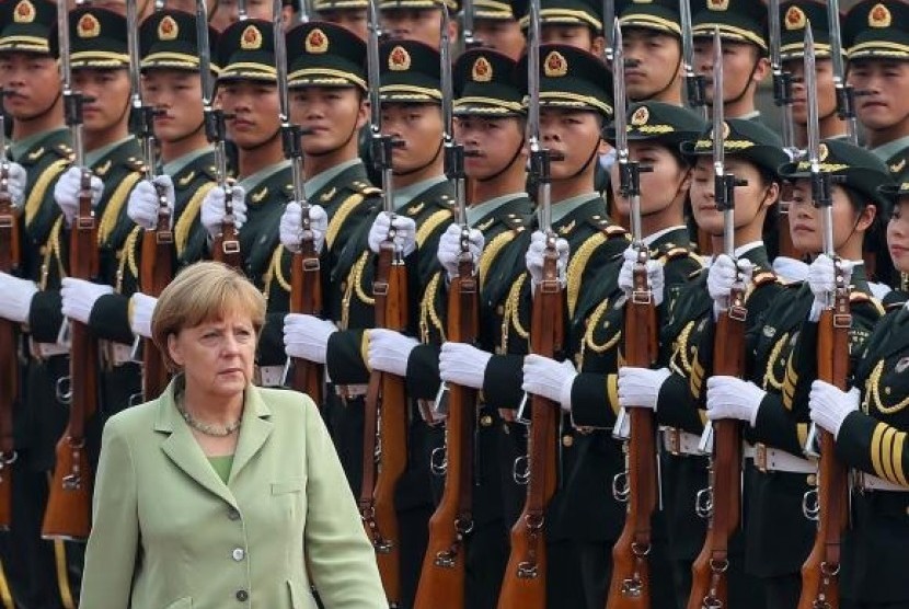 Germany's Chancellor Angela Merkel reviews an honour guard during a welcoming ceremony outside the Great Hall of the People in Beijing July 7, 2014.