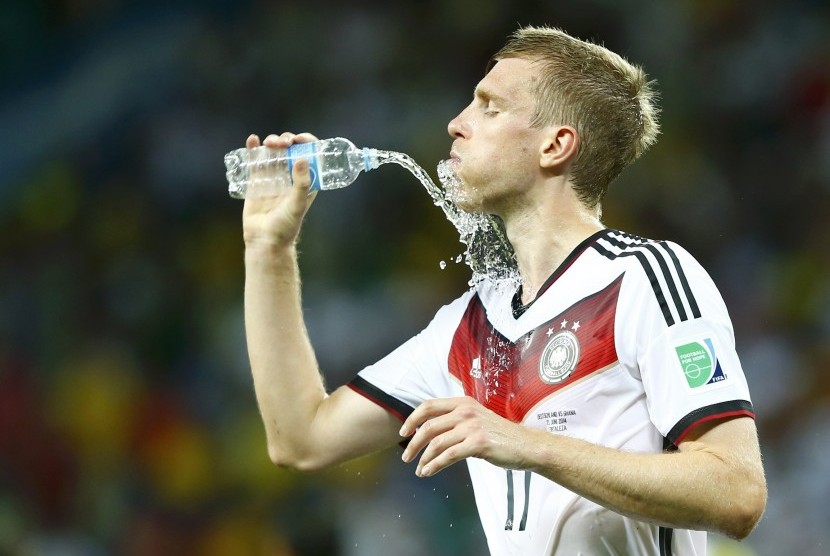 Germany's Per Mertesacker refreshes himself after the 2014 World Cup Group G soccer match between Germany and Ghana at the Castelao arena in Fortaleza June 21, 2014.