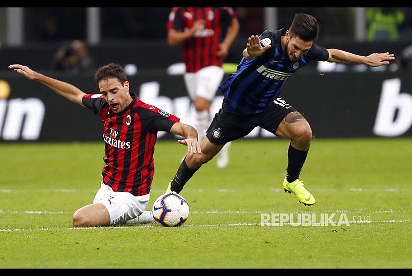 Giacomo Bonaventura (kiri) dan Matteo Politano (kanan) berebut bola pada laga derby antara Inter Milan dan AC Milan di Stadion San Siro, Milan, Senin (22/10) dini hari.