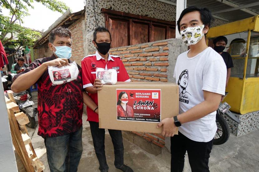 Gibran Rakabuming Raka (33 tahun) selaku kader PDIP bersama para relawan menyalurkan bantuan 6.000 masker nonmedis dan 2.000 masker medis dari Puan Maharani ke masyarakat Solo.