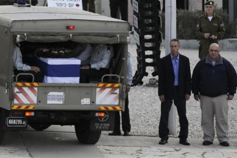 Gilad (second right) and Omri Sharon (uri), sons of the former Israeli Prime Minister Ariel Sharon stand next to his flag draped coffin, as its rests inside a vehicle, at the Israeli army's Armoured Corps' Memorial in Latrun, near Jerusalem January 13, 201